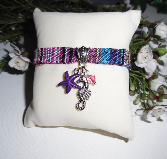 Pulseira de tecido colorido com cavalo marinho e borlas de estrela-do-mar roxas