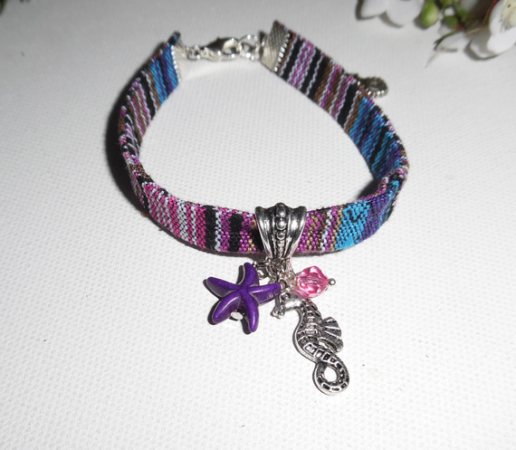 Pulseira de tecido colorido com cavalo marinho e borlas de estrela-do-mar roxas