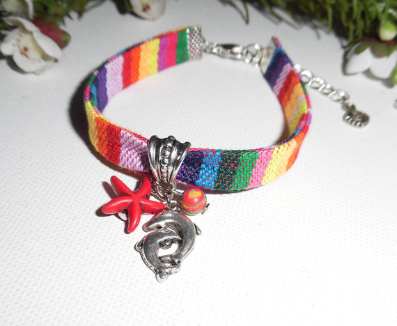 Pulseira de tecido colorido com borlas de golfinhos e estrelas-do-mar vermelhas