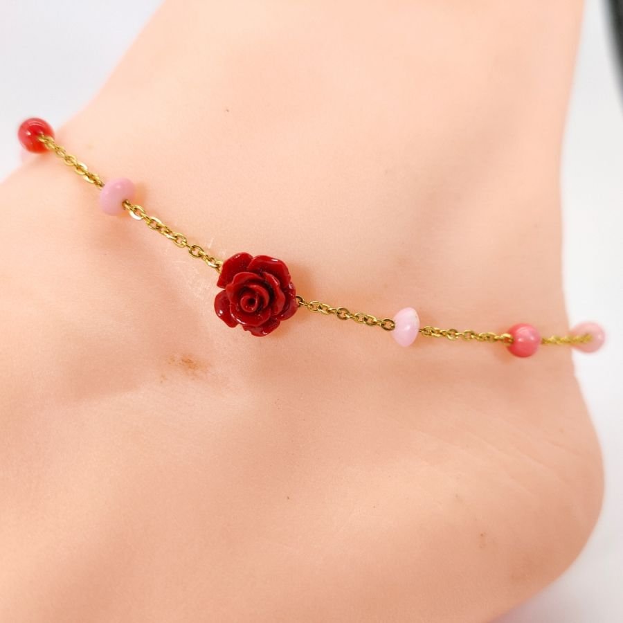 Tornozeleira de coral com rosa vermelha sobre corrente de aço dourada