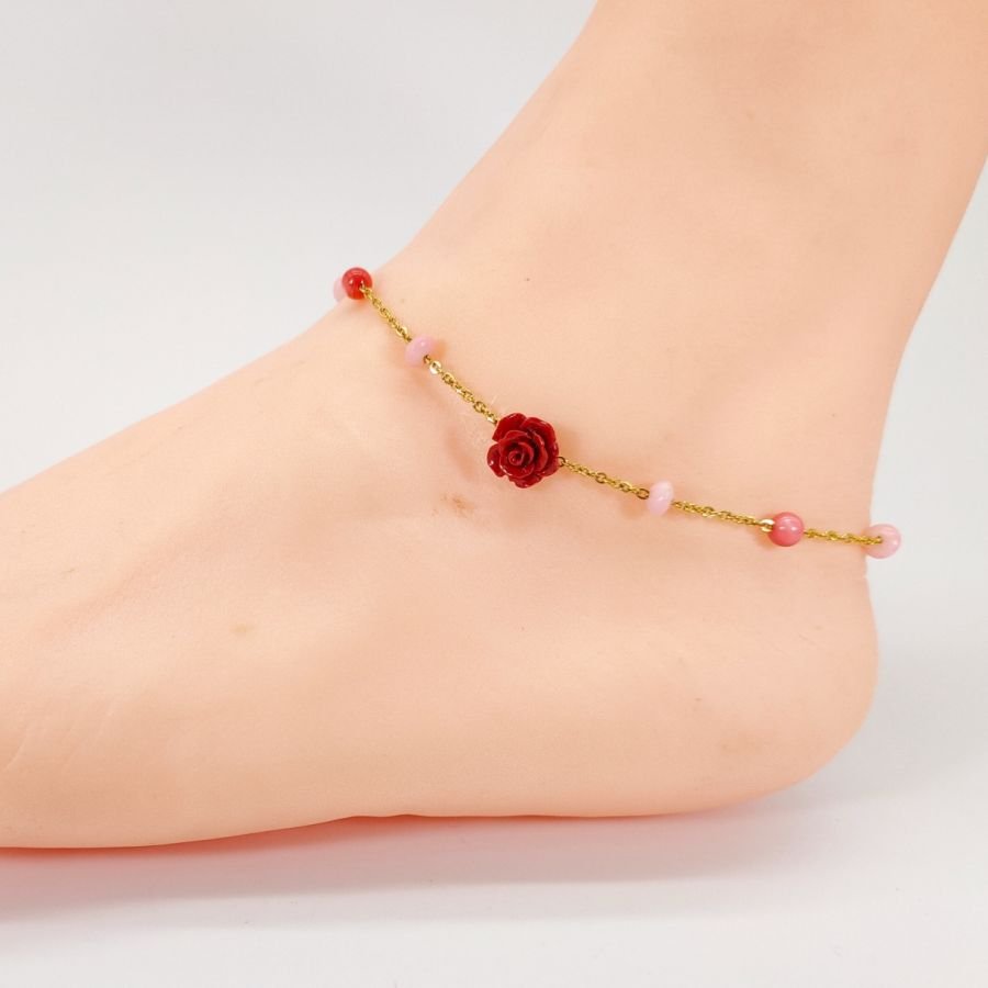 Tornozeleira de coral com rosa vermelha sobre corrente de aço dourada