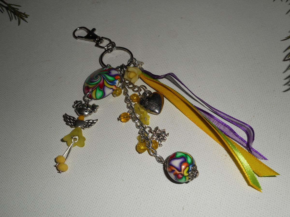 Porta-chaves/saco amarelo com missangas e fitas multicoloridas